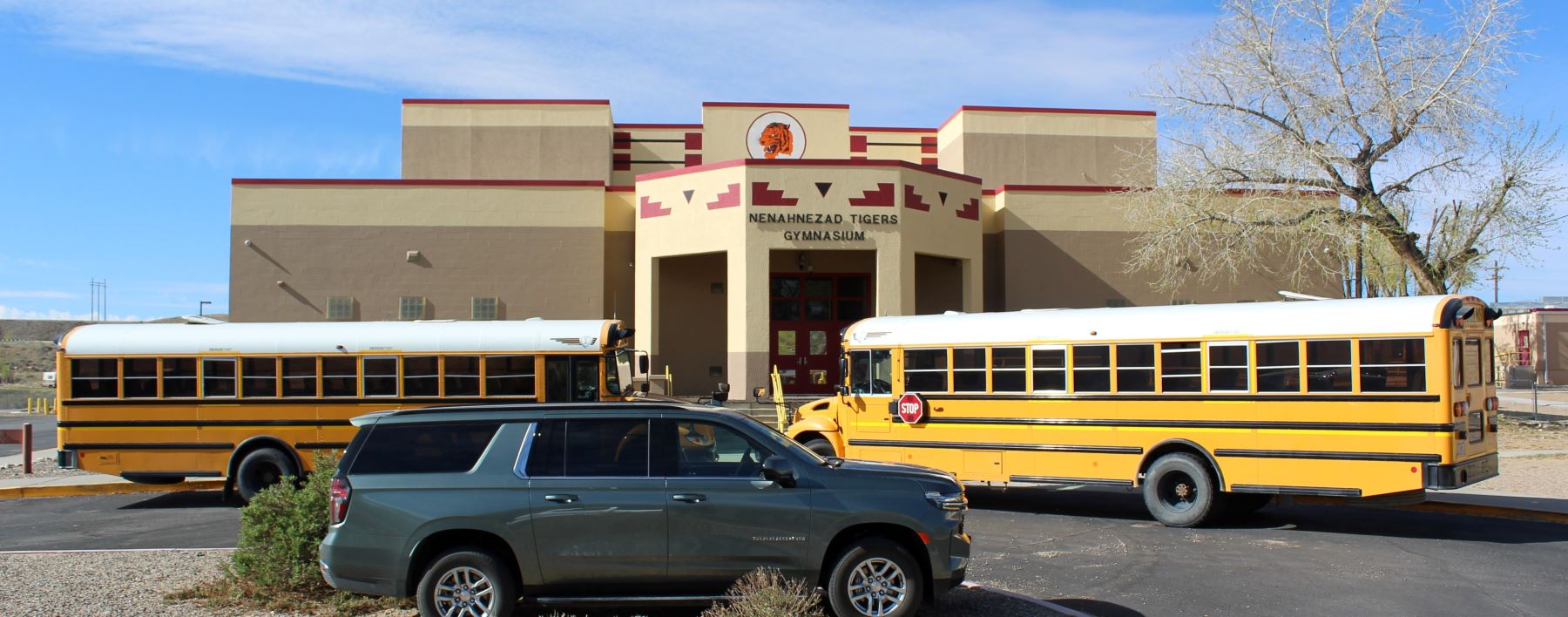 school buses parked in front of school building