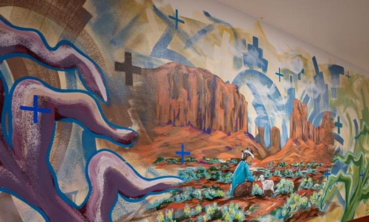 mural on school wall of person crouching down and tending to crops