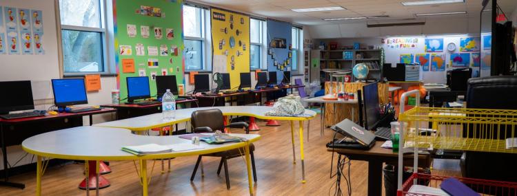 computer lined up on tables in classroom