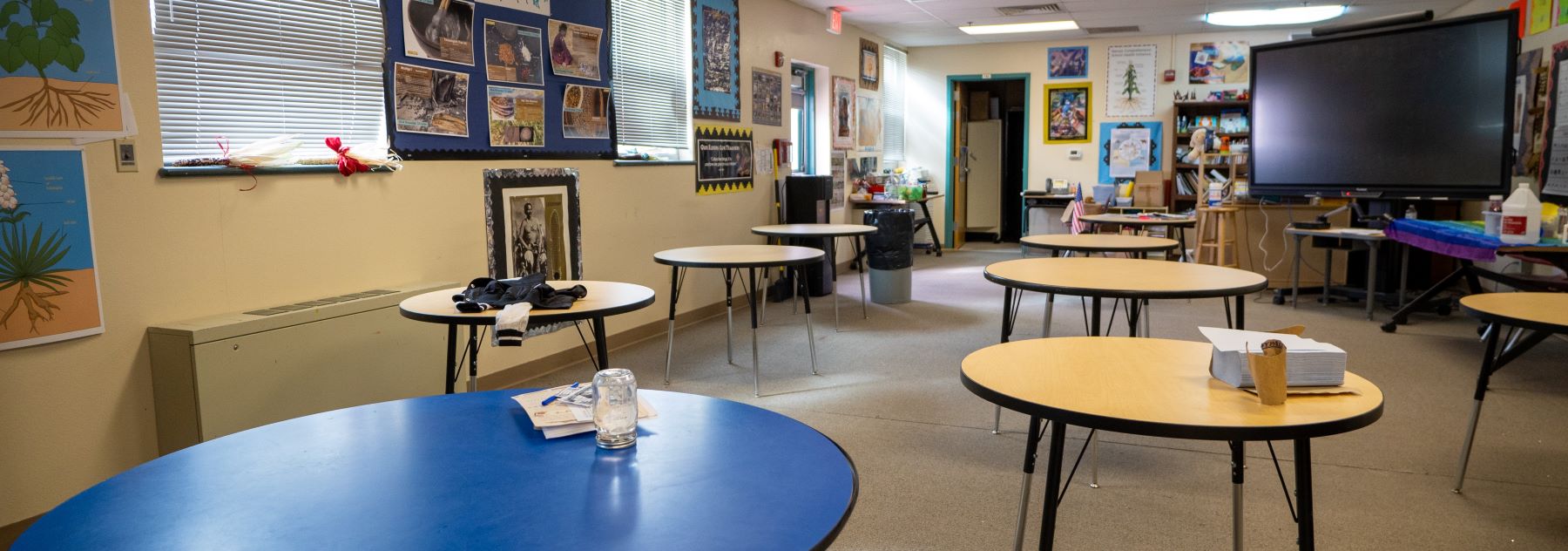 classroom with round tables and large monitor