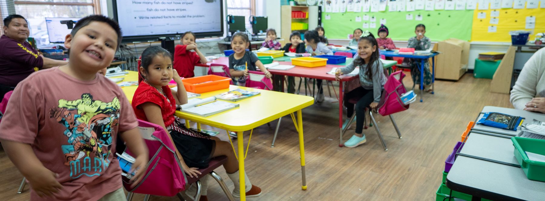 teacher and smiling students in classroom