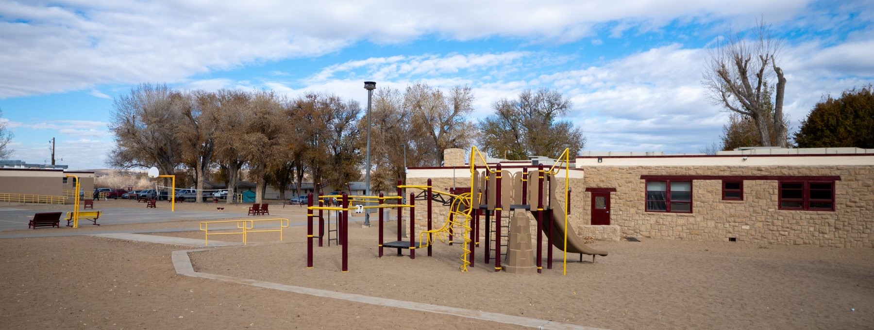 school building on a beautiful day with playground in front