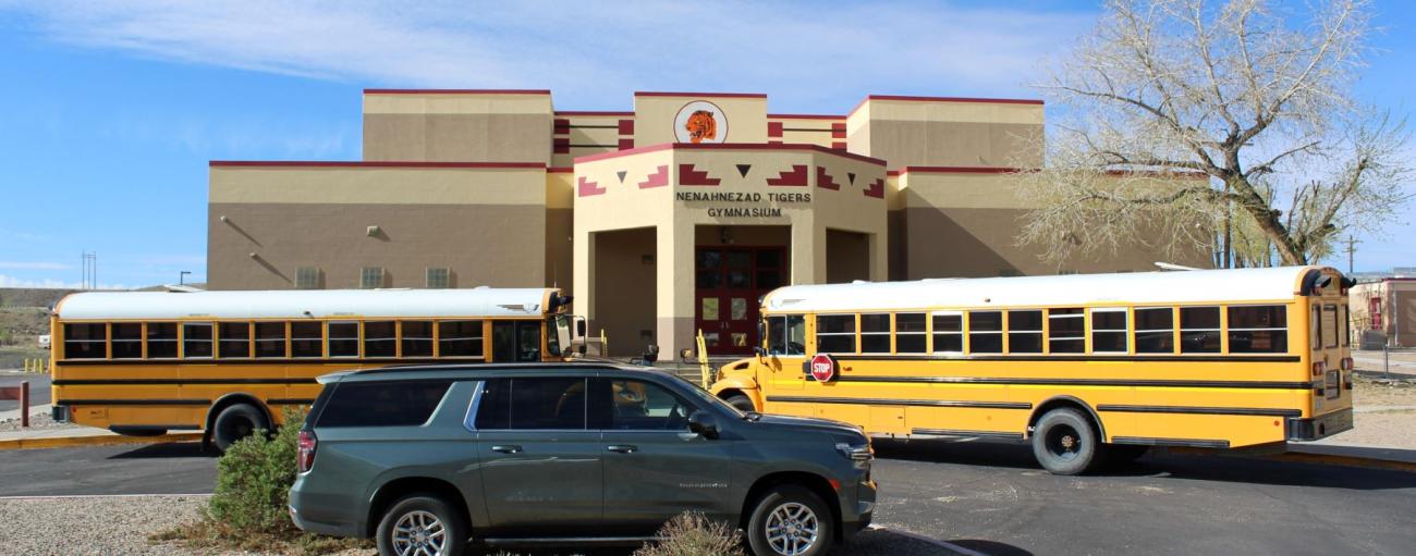 school buses parked in front of school building