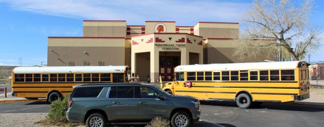 school buses parked in front of school building